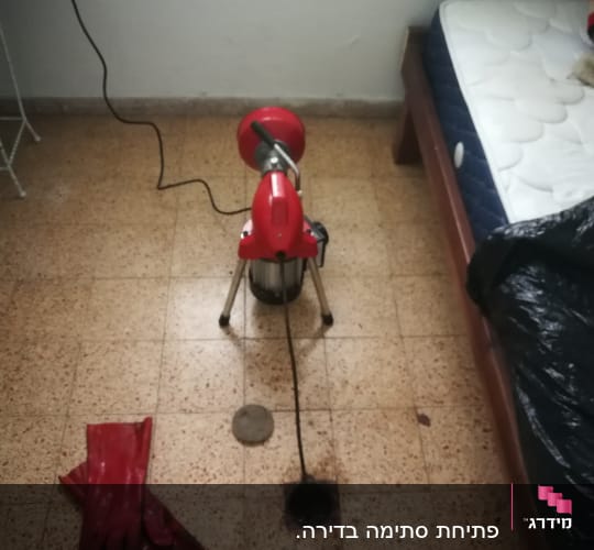 מכונת ניקוי צינורות אדומה עם כבל חשמלי